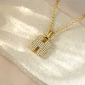 Detail shot of a gold hip hop necklace featuring a sparkling iced out letter H pendant - Letter H / Champagne Gold