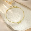 Close-up detail of a minimalist gold stainless steel bracelet with a letter K charm - Letter K Style / Gold