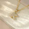 Detailed macro view of golden hip hop iced out initial K pendant necklace for women - Letter K / Champagne Gold