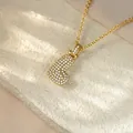 Close-up of iced out gold letter B pendant necklace with pavé set crystals - Letter L / Champagne Gold