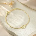 Macro detail of gold stainless steel bracelet with letter Q pendant and crystal charm - Letter Q Style / Gold