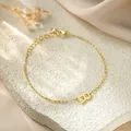Detailed macro view of a gold titanium steel bracelet with an 'R' pendant - Letter R Style / Gold
