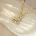 Close-up of a gold hip-hop necklace with a sparkling iced-out S letter pendant - Letter S / Champagne Gold