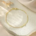 Detailed close-up of a gold titanium steel chain bracelet with a polished letter T charm. - Letter T Style / Gold