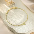 Close-up of elegant gold titanium steel bracelet featuring a minimalist V letter pendant - Style Letter V / Gold