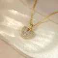 Detailed close-up of a gold-toned heart pendant necklace fully encrusted with clear stones. - Letter V / Champagne Gold