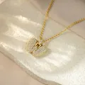 Detail shot of a gold-toned iced out letter pendant necklace set with glittering crystals - Letter W / Champagne Gold