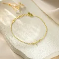 Close-up of gold titanium steel bracelet featuring a minimalist X letter charm - Letter X Style / Gold