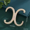 Elegant gold-tone pearl letter X brooch variant showing 5.6cm width and 24.5g weight - Letter X