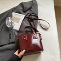 Dunkelrote glänzende Vintage-Beuteltasche mit goldenen Nieten und Umhängeriemen. - Ohne Anhänger / Rot