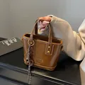Vintage brown leather bucket handbag with top handle and stylish woven decorative pendant - With Pendant / Brown