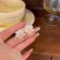 Nahaufnahme von eleganten weißen Blumenohrsteckern mit Perlen und funkelnden Zirkonia-Details - Blumen Perle Quasten Stil (A999) / Gold