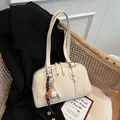 Stylish cream shoulder armpit bag with sports charm and glossy finish. - White + Pendant