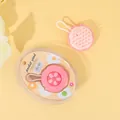 Primer plano del cepillo de silicona rosa para masaje capilar y su embalaje de flores - Caja de PVC / Rosa