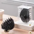 Leaf-shaped black scalp massage brush featuring coarse teeth and a premium gold-tone base - PVC Box / Black