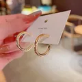 Macro view of polished gold C-shaped hoop earrings on a white thank you display card - C-Shape Open Hoop Style (A182)
