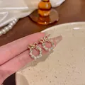 Elegant gold bow wreath stud earrings featuring white pearls and sparkling crystals. - Butterfly Ring Style (A066)