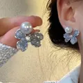 Close-up of elegant glittery blue butterfly earrings with a white pearl on an ear - Blue Butterfly Artificial Pearl Style (PD019银)