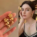 Elegant golden floral drop earrings showcased on a model for a stylish and luxury look - Floral Long Tassel Style (A2188 Gold) / Gold
