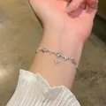 Elegant silver bracelet with sparkling zircons worn on a wrist for a delicate jewelry look - Four-Leaf Flower Pendant Style (S689) / Silver