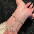 Elegant gold bowknot zircon bracelet for women featuring a delicate dangling star charm. - Bowknot and Star Style (S826) / Gold