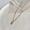 Elegant gold plated rectangular pendant necklace featuring a micro-paved crystal letter M. - Letter M Rhinestone Pendant Style (X196金) / Gold
