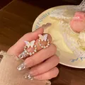 Elegant lavender butterfly rhinestone earrings with pearl wreath held by hand - Butterfly Pearl Wreath Style (E5659) / Gold