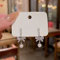 Elegant S925 silver bow earrings featuring sparkling crystals and drop pearls. - Bowknot Artificial Pearl Earrings Style (E6071) / Silver