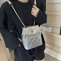 Un mannequin de mode portant un mini sac à dos matelassé argenté brillant à chaîne - Argent