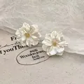 Elegant pearlescent white floral stud earrings with a golden center for daily wear - 立体贝母质感花朵款(A2244)