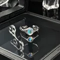 Detailopname van een zilveren open ring met maansteen en een elegante blauwe glans. - Verstelbare ring stijl 2