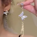 Macro view of elegant sparkling asymmetrical butterfly tassel earrings for women - Pave Rhinestone Butterfly Tassel Style (A1633)