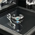 Close-up van een minimalistische zilverkleurige open ring met een ovale maansteen. - Verstelbare ring stijl 4