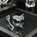 Detailopname van een zilveren ring met stekels en een hartvormige maansteen op zwart - Verstelbare ring stijl 5
