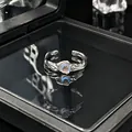 Gedetailleerde weergave van een minimalistische zilveren open ring met maansteen op zwart - Verstelbare ring stijl 6