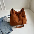 Bolso tote grande de nailon naranja con correa ajustable y cierre de cordón ajustable. - Naranja
