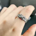 Close-up view of a silver ribbed X-shaped crossover ring with sparkling crystals on a finger - Cross Rope Knot Style (5399212638403)