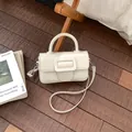 Elegant cream white small handbag with handle and crossbody strap on a stylish wood floor. - No Pendant / White