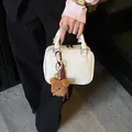 Elegante weiße kleine quadratische Handtasche mit süßem Teddybär-Anhänger für Damen - Bären-Anhänger-Stil / Gebrochenes Weiß