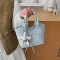 Chic light blue denim bucket handbag featuring a silver star charm and knot handle details - With Pendant / Blue