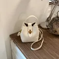 Elegante borsa a secchiello in pelle bianca con manico e fibbia dorata. - senza ciondolo / Bianco