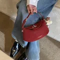 Elegante bordeauxrode lederen zadeltas voor dames met goudkleurige hardware en bedeltje - Rood Met Hanger