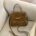 Elegant vintage brown textured women's handbag with gold lock on a white textured sofa. - S / Caramel color