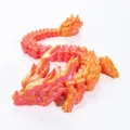 Close-up view of a 3D printed articulated dragon ornament in gradient fantasy orange color - 30cm / Dreamy Orange
