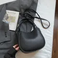 Minimalistische zwarte bucket bag van generfd leer met handvat en schouderriem - Zwart