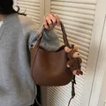 Chic brown leather bucket bag for women featuring a cute bear pendant, SKU variant - Coffee with Charm
