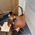 Elegant brown pebble leather crescent bucket bag with a cute teddy bear charm pendant - Brown with Charm
