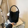 Minimalistische schwarze Vintage-Beuteltasche mit Griff und weißem Plüsch-Anhänger - Mit Anhänger / Schwarz