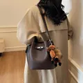 Elegant brown leather bucket bag with a cute plush horse charm for a vintage look. - With Pendant / Coffee