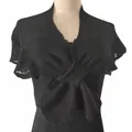 Detail view of black knitted wrap shawl with elegant front twist on mannequin - Black